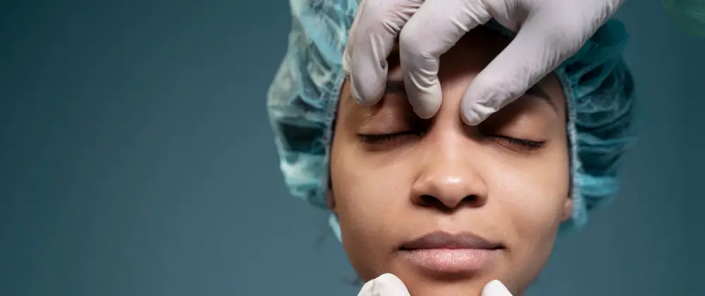Healthcare professional examining a woman’s face before a cosmetic or facial treatment procedure.