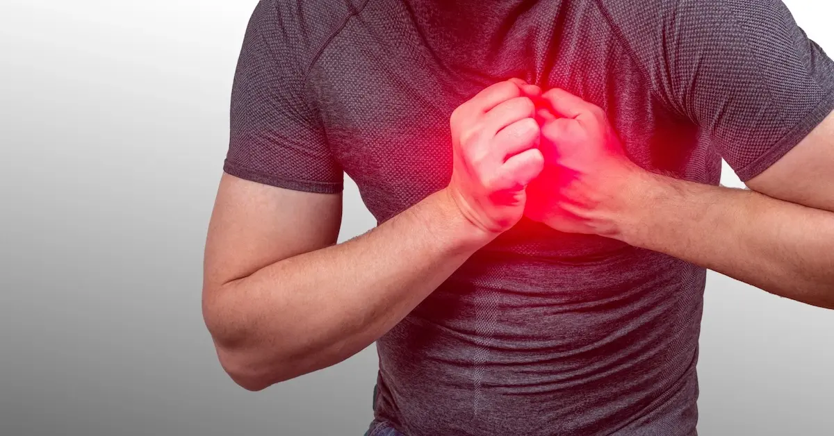 Man experiencing chest pain with hands placed over the chest and a red highlighted heart area.