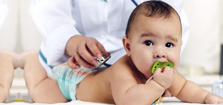 Baby undergoing a routine paediatric health examination with a doctor using a stethoscope.